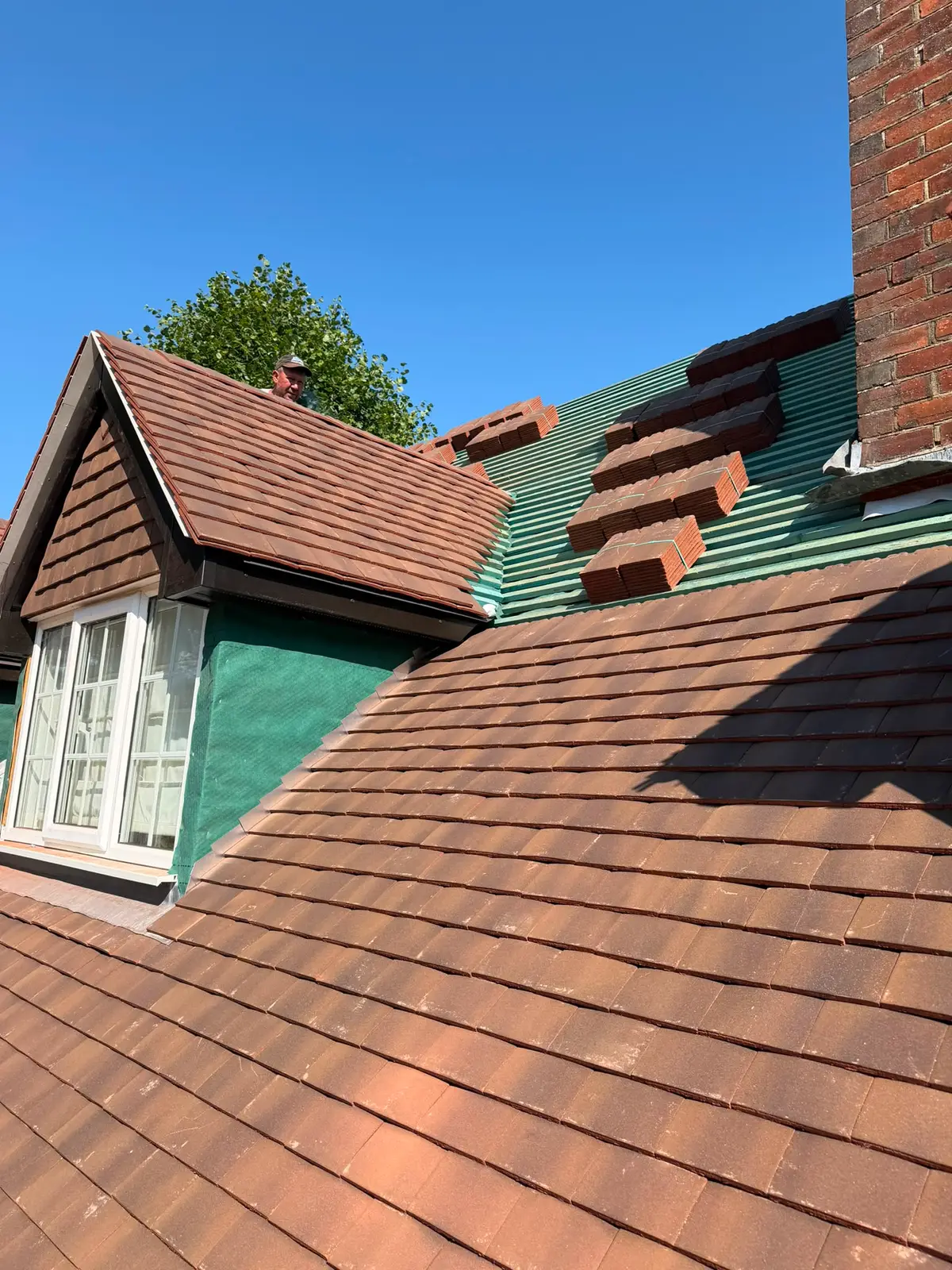 Freshly laid roof tiles around a dormer and chimney on a Newbury re-roof
