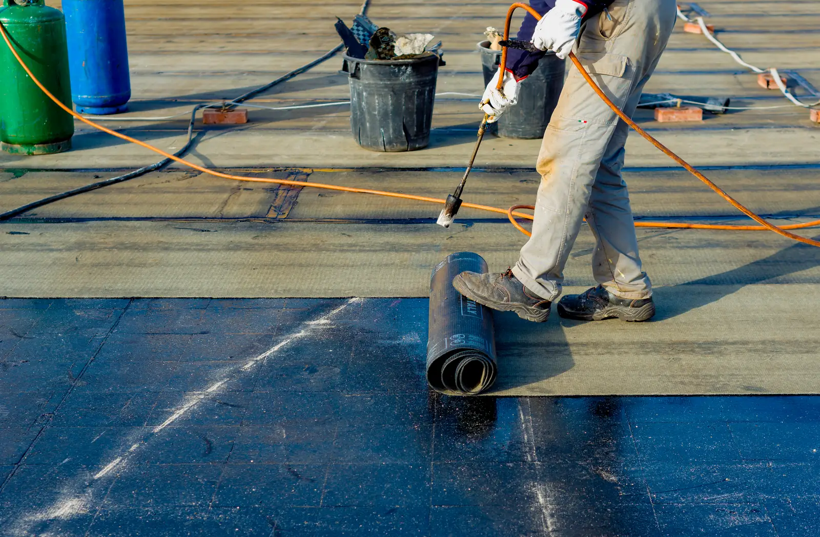 Flat roof roofer priming felt membrane installation